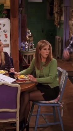 two women sitting at a table with food in front of them on the set of friends