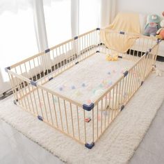 a baby crib in the middle of a living room with a teddy bear and stuffed animals