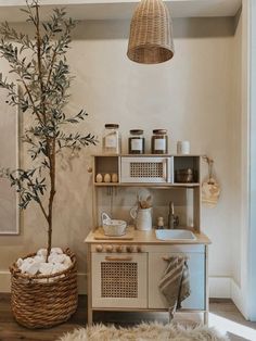 a kitchen with a tree in the corner and other items on the shelf next to it