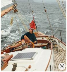 a man sitting on the deck of a sailboat