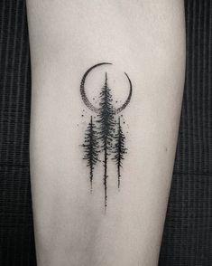 a black and white photo of a forest with a half moon tattoo on the thigh