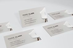 four business cards with the name marie clark on them, all in different shapes and sizes