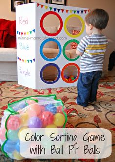 a young boy standing in front of a box with balls on it and the words, color sorting game with ball pit balls