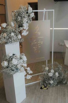 the wedding cake is decorated with white flowers and greenery on display at the reception