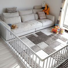 a living room with a white couch and rugs on the floor in front of a window