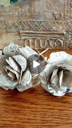 two paper roses sitting on top of a wooden table