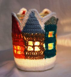 a crocheted cup with a lit candle in it