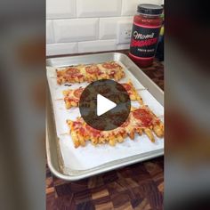 a pan filled with pizza sitting on top of a counter next to a bottle of ketchup