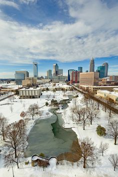 an aerial view of a city with snow on the ground and buildings in the background