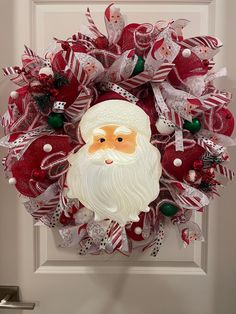 a christmas wreath with santa's face on it hanging on the front door,