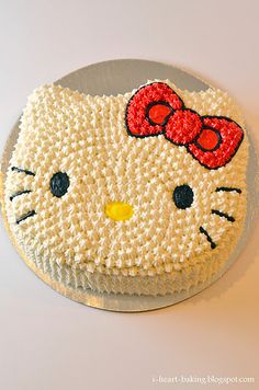 a hello kitty cake with red bow on it's head is shown in front of a white background