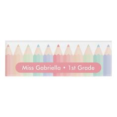 a pencil box with the name miss gabrilla 1st grade written on it and colored pencils