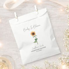 a white bag with a sunflower on it and some wine glasses next to it