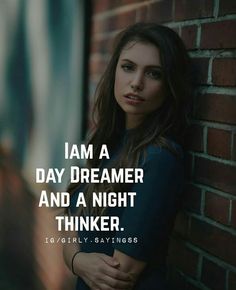 a woman leaning against a brick wall with the words i am a daydreame and a night thinker