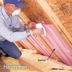 a man is working on insulation in the attic