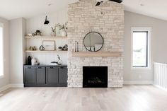 a living room filled with furniture and a fire place in front of a brick fireplace