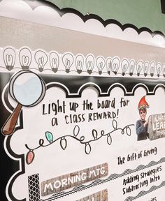 a bulletin board has been decorated with christmas lights and holiday decorations, including a magnifying glass for a reward