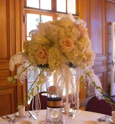 a vase filled with flowers sitting on top of a table next to plates and silverware