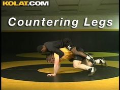 a man in black shirt and yellow shorts on a wrestling mat with words that read countering legs