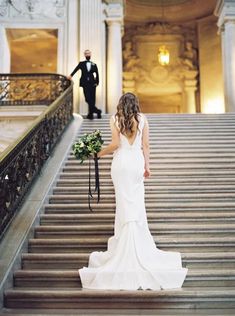 a bride and groom are walking down the stairs