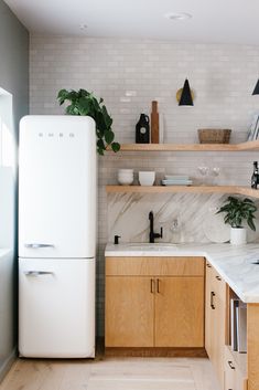 a white refrigerator freezer sitting inside of a kitchen next to wooden cabinets and counter tops