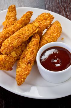 fried chicken sticks and dipping sauce on a white plate