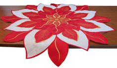 a red and white poinsettia sitting on top of a wooden table