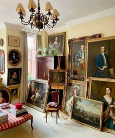 a living room filled with lots of paintings and furniture