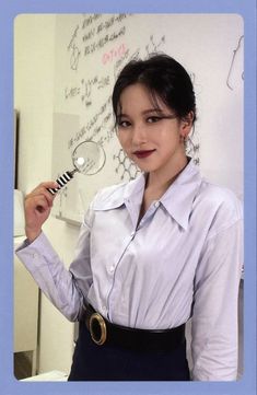 a woman holding a magnifying glass in front of a whiteboard with writing on it