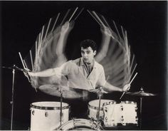 a black and white photo of a man playing drums