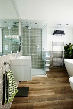 a bathroom with wood flooring and tiled walls