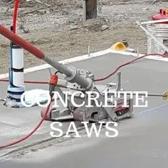 concrete saws are laying on the ground next to a pipe and some other tools