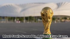 a soccer ball sitting on top of a wooden table next to a white building with mountains in the background