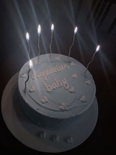 a birthday cake with lit candles on it and the words baby written in white frosting