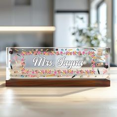 a clear acrylic sign that says mrs kayna