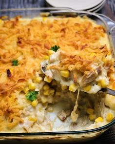 a casserole dish with chicken and corn in it is being lifted by a fork