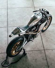 a silver motorcycle parked on top of a cement floor