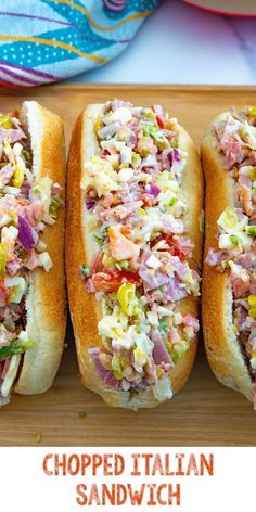 three hot dogs with toppings sitting on a cutting board