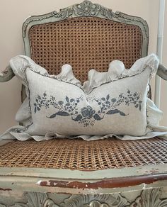 a chair with a pillow on top of it next to a wooden frame and wall