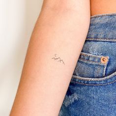 a woman's arm with a small tattoo on the left side of her arm