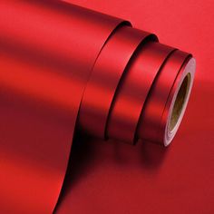 a roll of red tape on top of a red surface