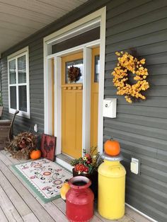 the front porch is decorated for fall with pumpkins and other things to decorate on it