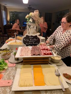 a woman standing in front of a table filled with food