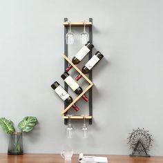 a wall mounted wine rack with several bottles and glasses on it, next to a plant