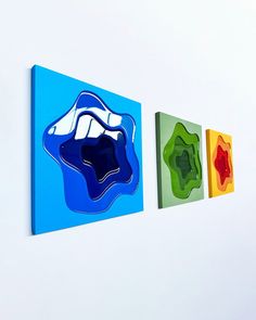 three abstract paintings hang on the wall next to each other