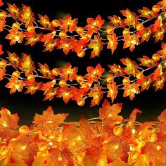 an arrangement of autumn leaves with lights on them