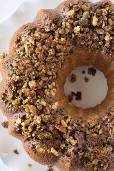 a bundt cake on a plate with pecans and nuts around the top, ready to be eaten