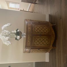 an ornate wooden cabinet and mirror in a room with wood flooring on the walls