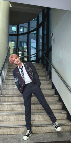 a man in a suit and tie standing on some stairs with his head sticking out