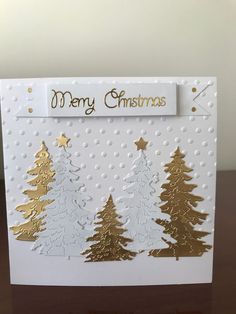 a christmas card with gold and white trees